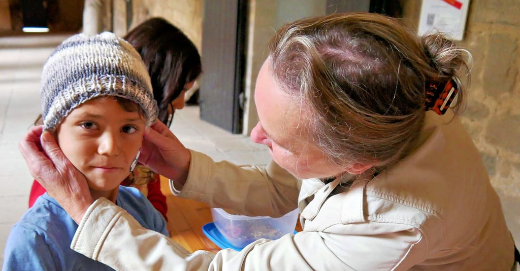 Sigrid Hoppe setzt hier einem der Kinder die passende Mütze auf. Gemeinsam mit Birgit Eberding hatte sie Schals und Mützen für Kinder und Erwachsene gestrickt, die ruck, zuck vergriffen waren.