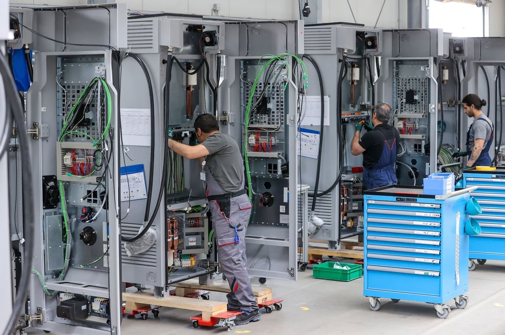 Mitarbeiter verdrahten im Leipziger Siemens-Werk Ladesysteme für Elektroautos.