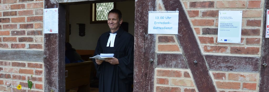 Pfarrer Silvio Scholz aus Dähre wartet am Eingang der Fachwerkkapelle Klein Chüden auf Besucher des ersten Erntedankgottesdienstes in der Kapelle, seit ihrem Umzug ins Museumsdorf.