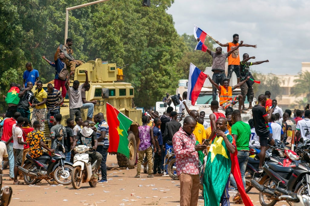 Anhänger von Hauptmann Traore jubeln mit russischen Fahnen in den Straßen von Burkina Fasos Hauptstadt Ouagadoudou.