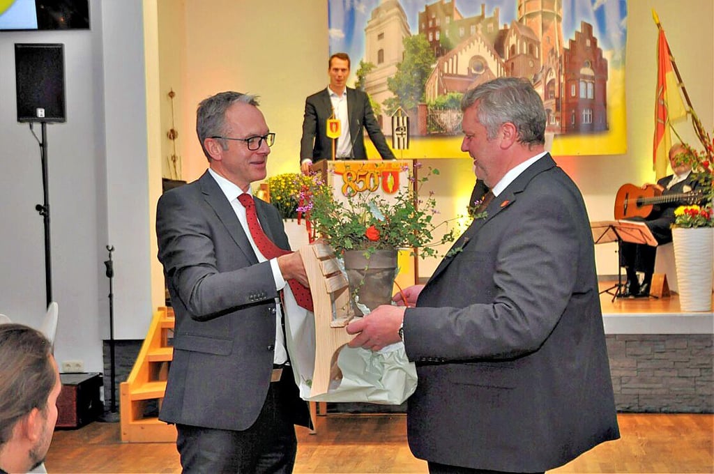 Andre Dora übergibt Matthias Günther eine kleine Bank als Zeichen dafür, dass Datteln Genthin eine Bank sponsert.