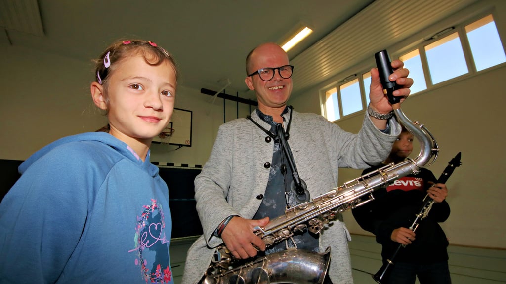 Jerzy Bojanowski steht hier mit Jasmin und Connor aus der Calbenser Lessingschule. Der Orchestermusiker will den Kindern Lust auf Musik machen.