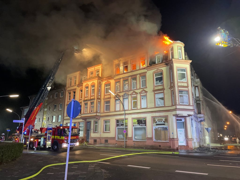 Feuerwehrleute beim Löscheinsatz am brennenden Wohnhaus.