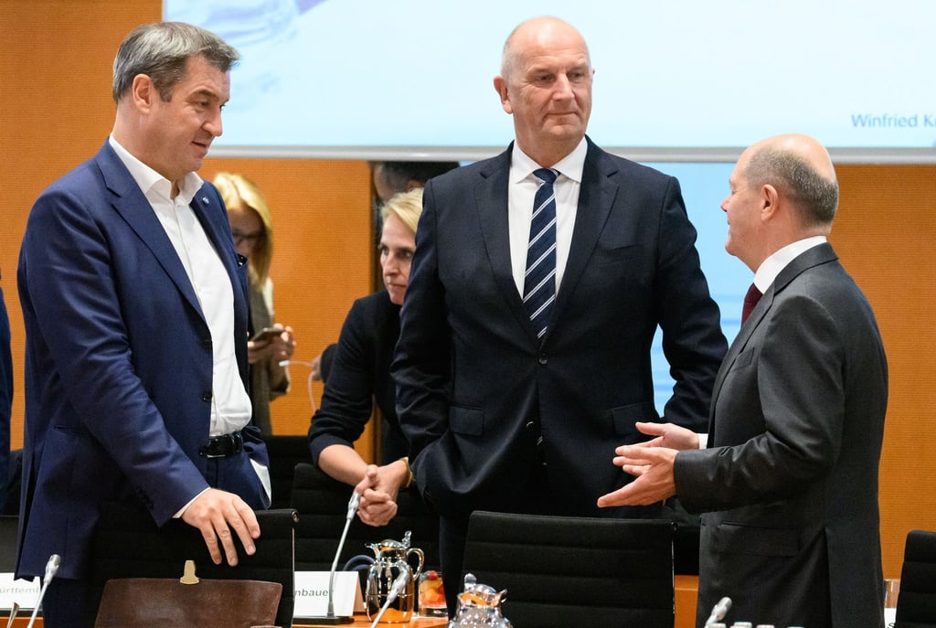 Markus Söder (l-r, CSU), Ministerpräsident von Bayern, Dietmar Woidke (SPD), Ministerpräsident von Brandenburg, und Bundeskanzler Olaf Scholz (SPD) unterhalten sich .
