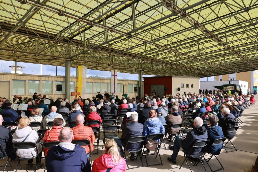 Besucher sitzen beim traditionellen ökumenischen Bittgottesdienst zum Thema „Frieden“ unter dem Gebäude der PKW-Einreise in die ehemalige DDR an der ehemaligen Grenzübergangsstelle Marienborn.
