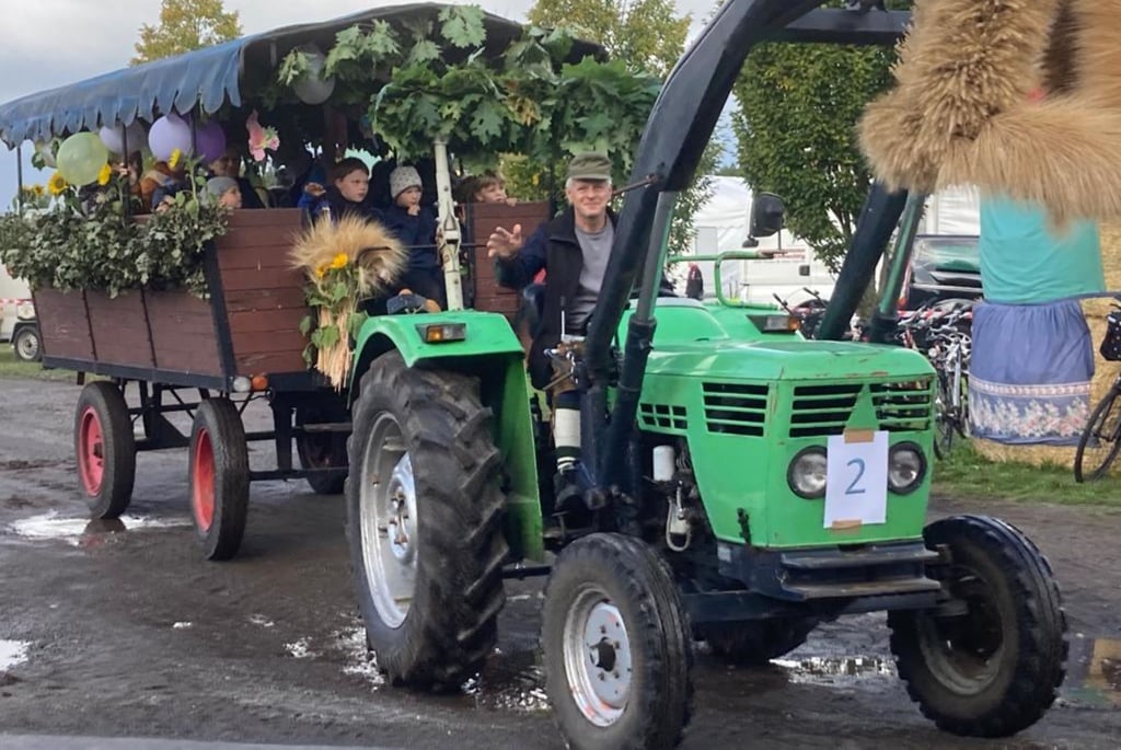 Ortsbürgermeister Jürgen Staschull fuhr dem Festzug mit seinem Traktor voran. Im Anhänger hatten Kinder Kitas aus Kleinwusteritz und Roßdorf Platz genommen und winkten den Zuschauern am Straßenrand zu.