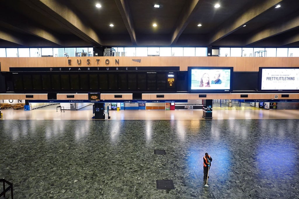 Eine Person wischt den Boden vor einer leeren Abfahrtstafel im Bahnhof Kings Cross, da die Mitglieder der Fahrergewerkschaft Aslef und der Transport Salaried Staffs Association (TSSA) streiken.