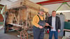 Marcel Guderjahn und Dr. Christian Marlow vor der historischen Dreschmaschine in der Werkstatt des Technikmuseums. 