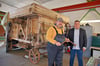 Marcel Guderjahn und Dr. Christian Marlow vor der historischen Dreschmaschine in der Werkstatt des Technikmuseums. 