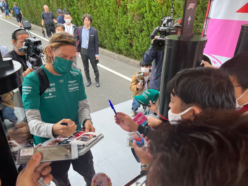 Formel-1-Fahrer Sebastian Vettel (Aston Martin) schreibt bei der Ankunft an der Rennstrecke Autogramme.
