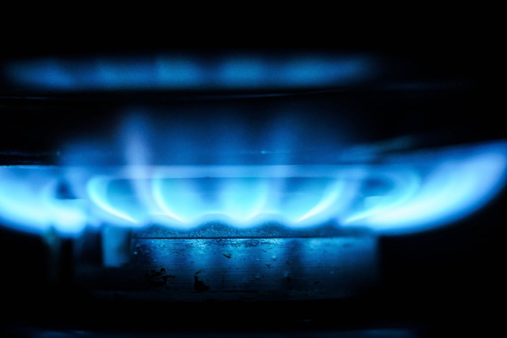 Eine Gasflamme erhitzt am frühen Morgen das Teewasser in einem Kochtopf.