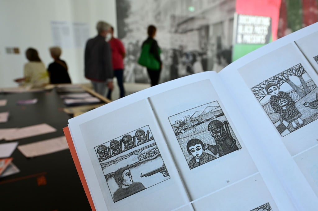 Eine Frau hält auf der documenta fifteen im Fridericianum die Broschüre mit dem Titel „Presence des Femmes“, die 1988 in Algier erschienen ist, in den Händen. Sie enthält weitere als antisemitisch kritisierte Motive.