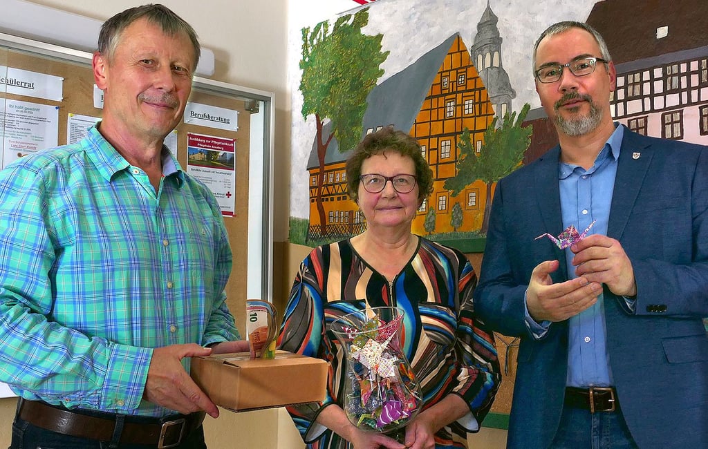 Angela Demele und Bürgermeister Stefan Schmidt (r.) überreichen an den Schulleiter der Annaburger Sekundarschule, Matthias Weiß (l.), knapp 1.300 Euro aus ihrer Kranich-Spendenaktion für die Ukraine.
