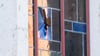 Eine Ermittlerin schaut durch ein beschädigtes Fenster an der Synagoge der Jüdischen Gemeinde.