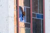 Eine Ermittlerin schaut durch ein beschädigtes Fenster an der Synagoge der Jüdischen Gemeinde.
