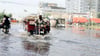Ein Mann fährt im September in Karatschi mit einem Fahrzeug eine überflutete Straße entlang. Die durch überlaufendes Abwasser gefluteten Straßen verursachen große Probleme.