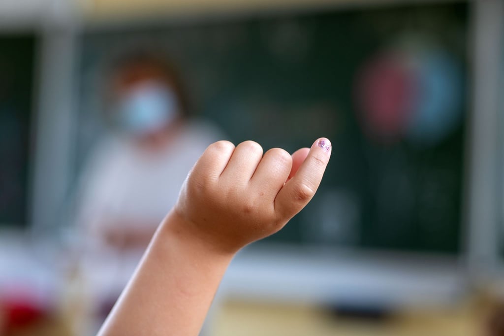 Ein Kind meldet sich in einer Grundschule.