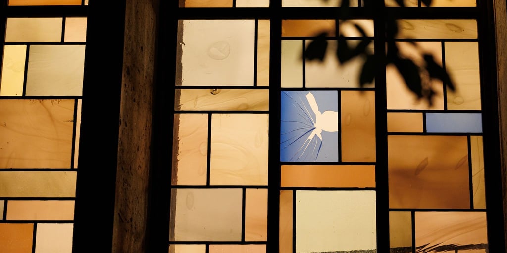 Ein beschädigtes Bleiglasfenster ist von der Außenseite der Synagoge aus zu sehen.
