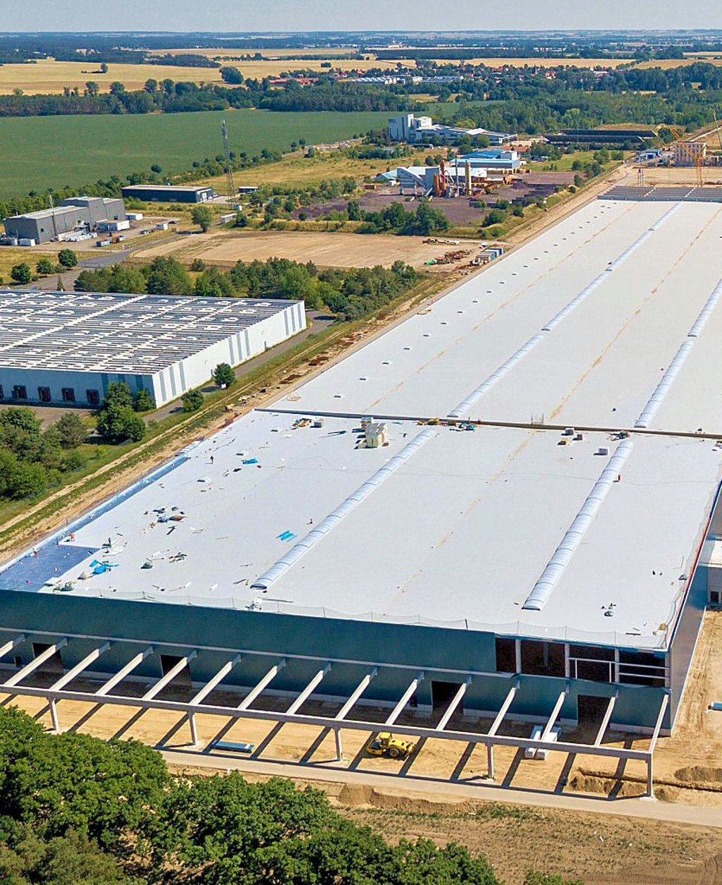 Die Luftaufnahme macht die Größe der Giga-Factory im Industriegebiet bei Stegelitz deutlich. Ende des Jahres soll die Produktionsstätte für Holzhäuser fertiggestellt sein.
