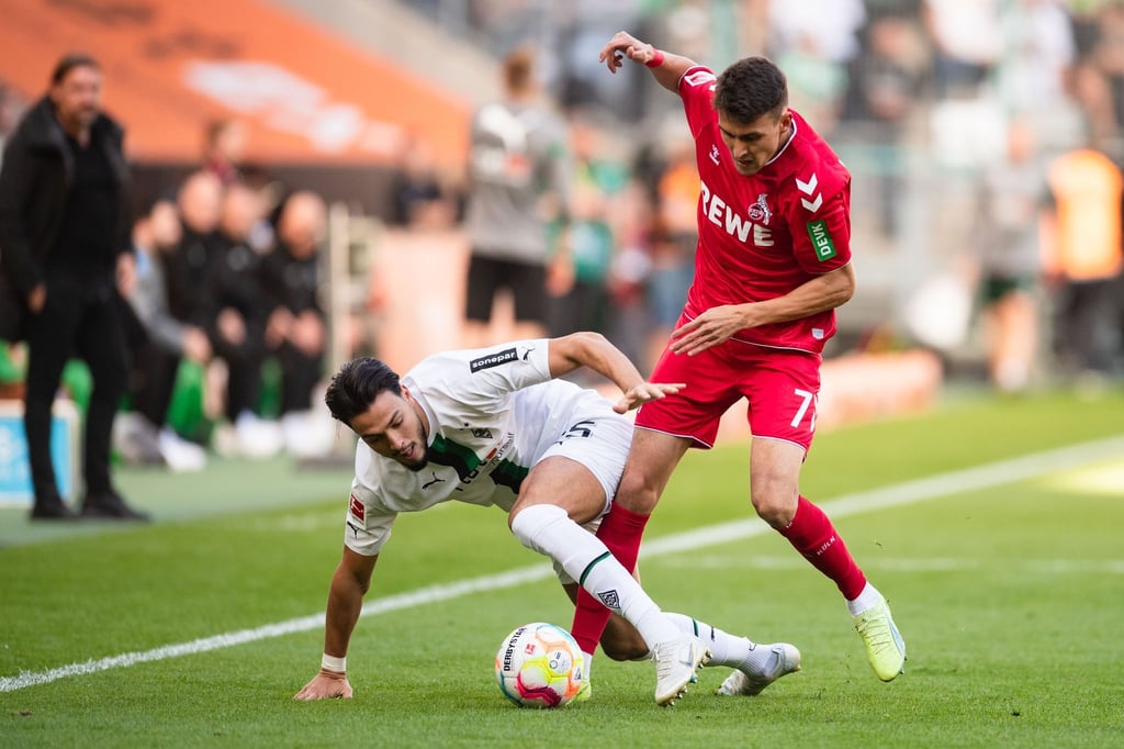 Kölns Dejan Ljubicic (r) und Gladbachs Ramy Bensebaini kämpfen um den Ball.