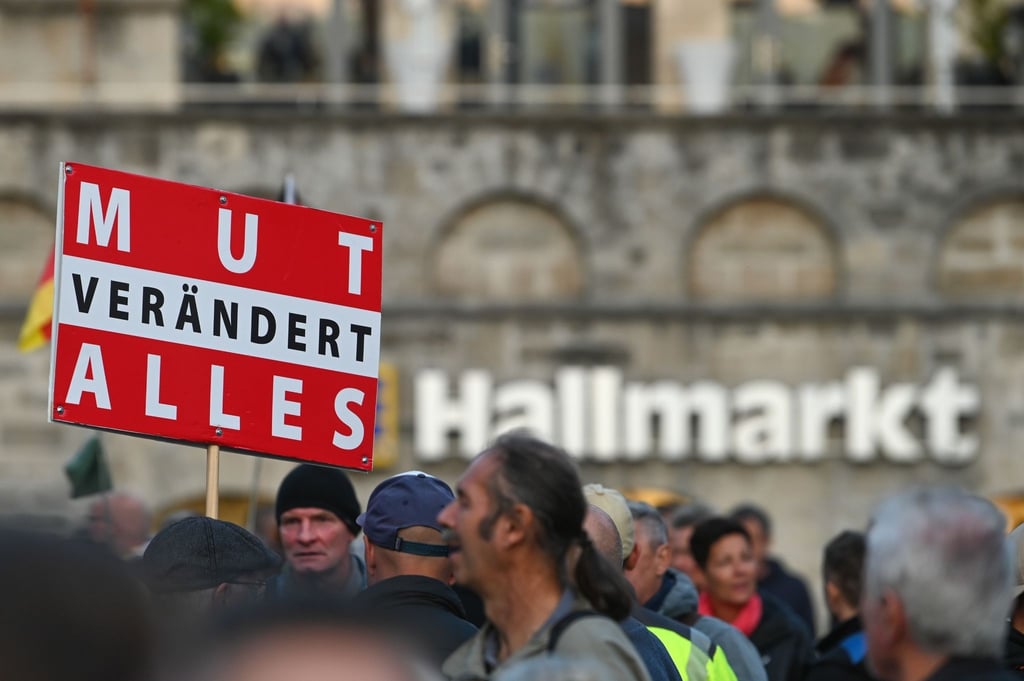Ein Plakat mit der Aufschrift „Mut verändert alles“ ist bei einer Demo auf dem Hallmarkt zu sehen.