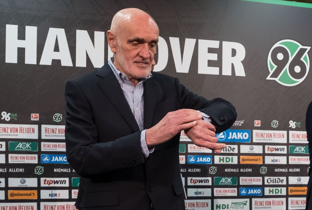 Martin Kind schaut während einer Pressekonferenz auf seine Uhr.
