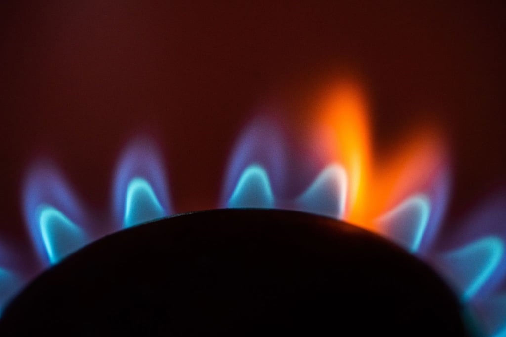 Die Flamme eines Gasherdes brennt in einer Küche.