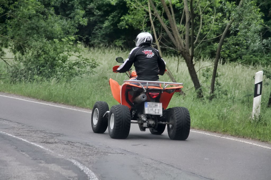 Ein Quad fährt auf einer Straße.
