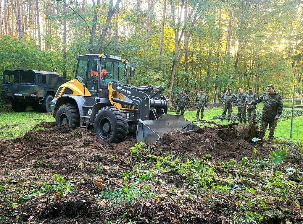 Bei der gründlichen Herrichtung des Friedhof-Areals bei Müggenbusch kommt auch Pioniertechnik zum Einsatz, Hier unter anderem für die Schaffung einer Parkmöglichkeit. Im Hintergrund ein 10-Tonner Lkw vom Typ MAN.