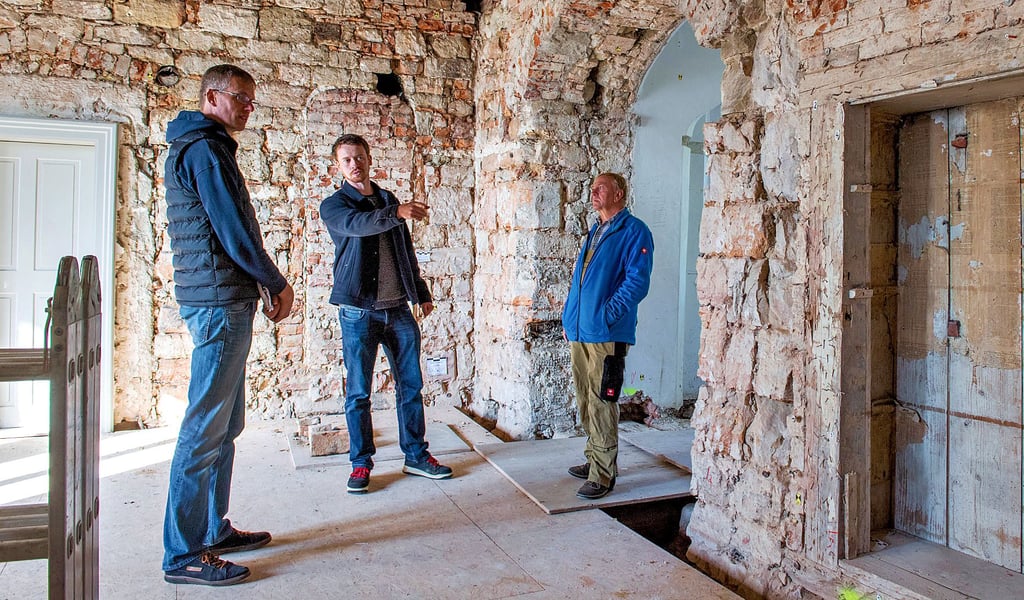 Olaf Martin-Knauf (l.) und Kai Metzner (M.) vom Baureferat der Kulturstiftung, im Gespräch mit Hausmeister Peter Müller im künftigen Aufenthaltsraum der geplanten Herberge im Schloss Goseck.