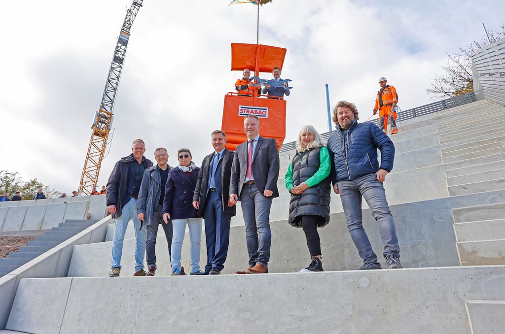 Wirtschaftsminister Sven Schulze (CDU) schwebt in einer Gondel mit Sebastian Bruch von der Baufirma Epesta über dem Bergtheater. Auf der neuen Tribüne stehen (von links) Andrè Drachau, Ronny Große, Cornelia Sieker, Thomas Balcerowski, Maik Zedschack, Petra Schulze und Stefan Oberacker.