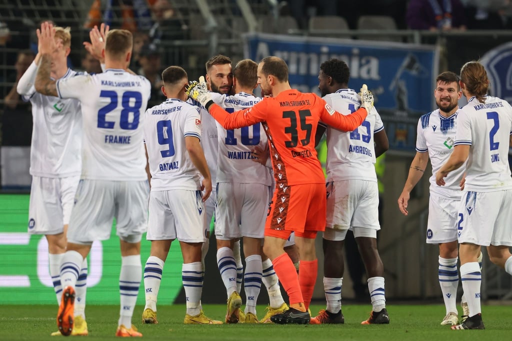 Die Karlsruher Spieler feiern den Sieg bei Arminia Bielefeld.