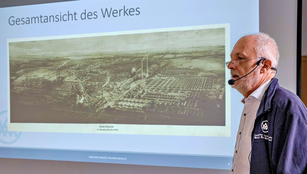 Vereinsvorsitzender Joachim Zander vor einer historischen Aufnahme des riesigen Werksgeländes