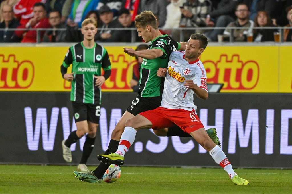 Regensburgs Benedikt Saller (r) versucht den Fürther Max Christiansen vom Ball zu trennen.