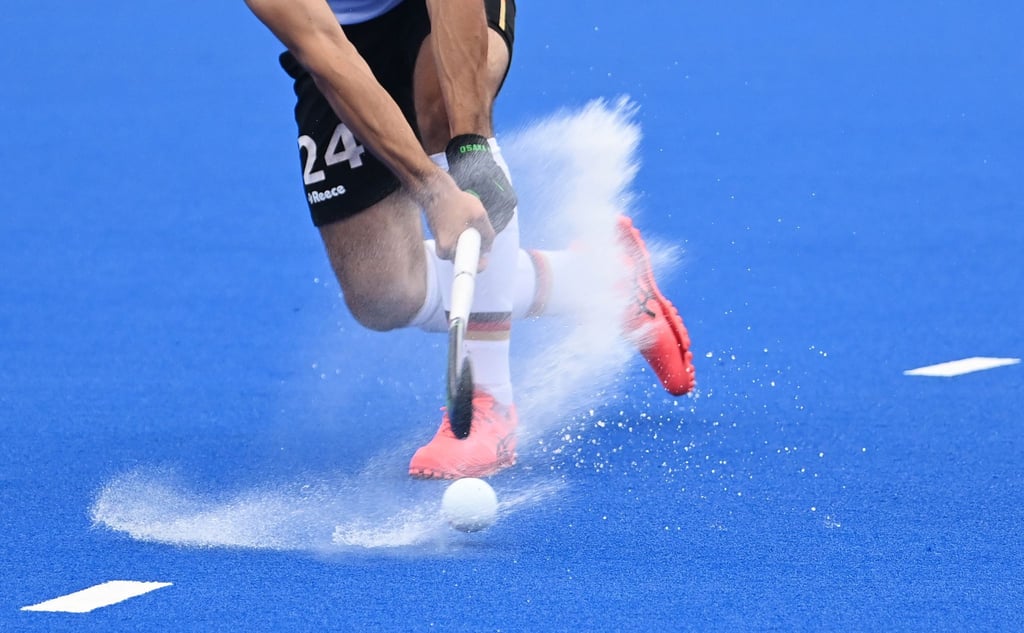 Ein Hockeyspieler spielt den Ball.