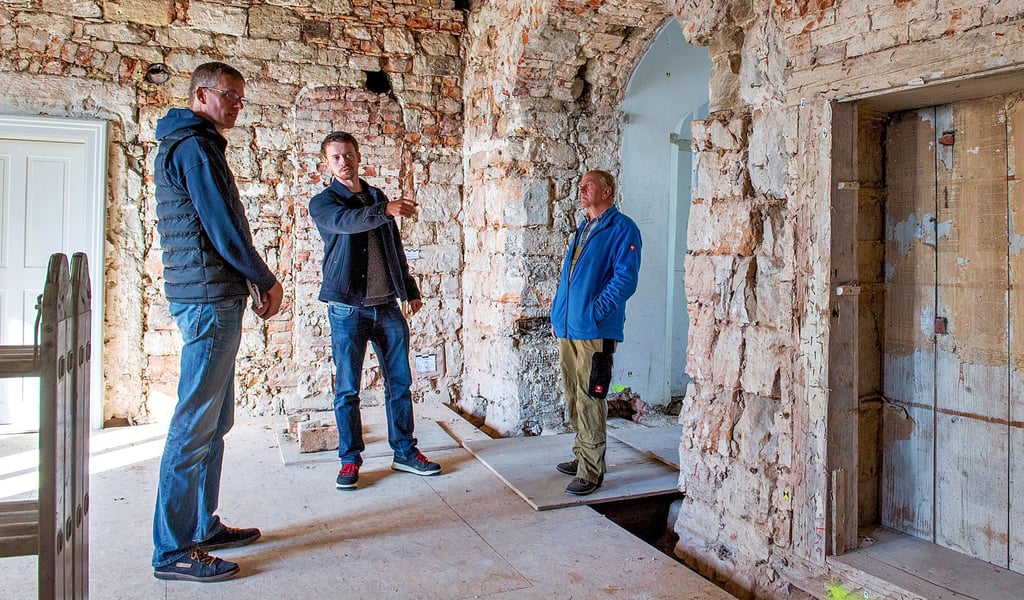 Olaf Martin-Knauf (l.) und Kai Metzner (M.) vom Baureferat der Kulturstiftung im Gespräch mit Hausmeister Peter Müller im künftigen Aufenthaltsraum der geplanten Herberge im Schloss Goseck.