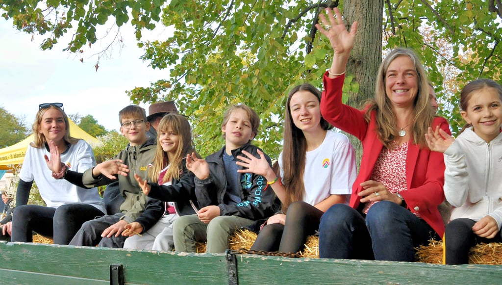 Kinder und Erzieher der Ökostation-Wohngruppe wurden gemeinsam mit Anna Manser, Mitglied des Stiftungsvorstandes, auf dem Anhänger eines Lanz-Bulldog-Oldtimer zum Festzelt chauffiert.