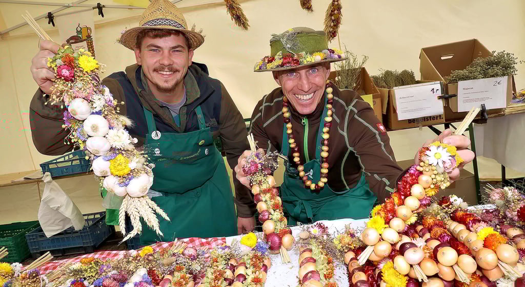 Jonas (l.) und Udo Pötzschke aus Heldrungen präsentieren bei 19. Hettstedter Zwiebelmarkt ihre Zwiebelrispen.