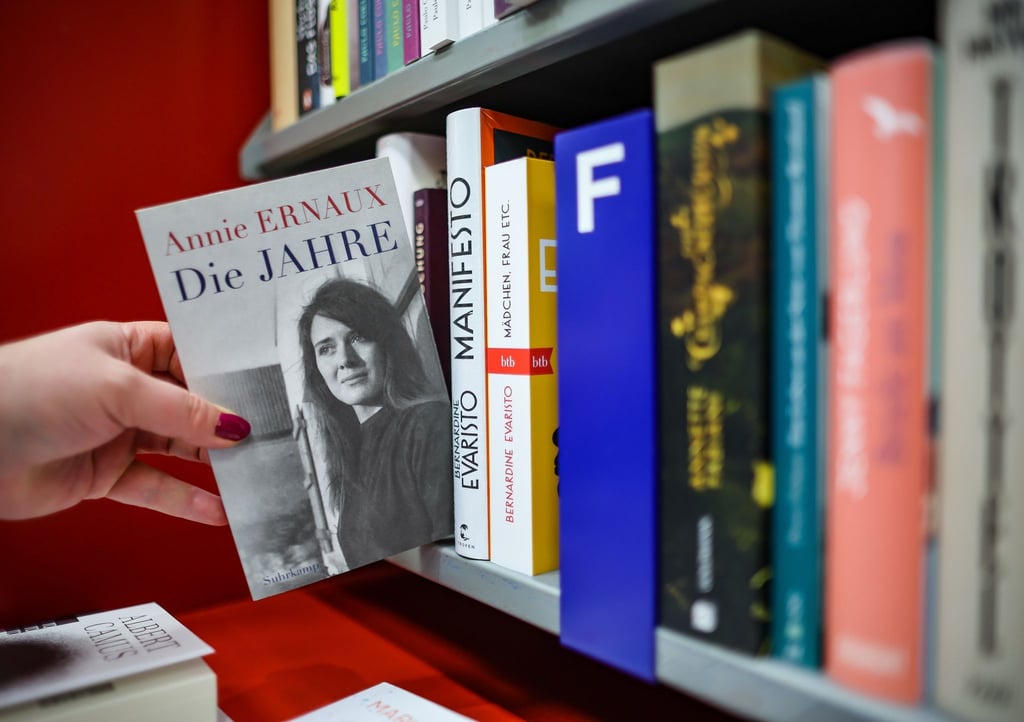 Eine Frau zieht das Buch „Die Jahre“ von Annie Ernaux in einer Leipziger Buchhandlung aus dem Regal. Die französische Schriftstellerin Annie Ernaux erhält den Literaturnobelpreis.