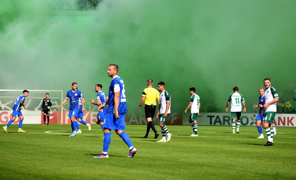 Lübecker Fans zünden grüne Rauchfackeln ab und sorgen für eine Spielunterbrechung.