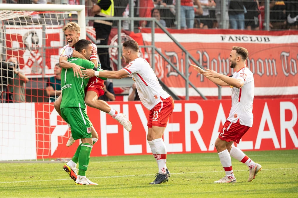 Regensburgs Dejan Stojanovic (l-r), Nicklas Shipnoski, Jan Elvedi und Benedikt Gimber feiern den Sieg im Elfmeterschießen.