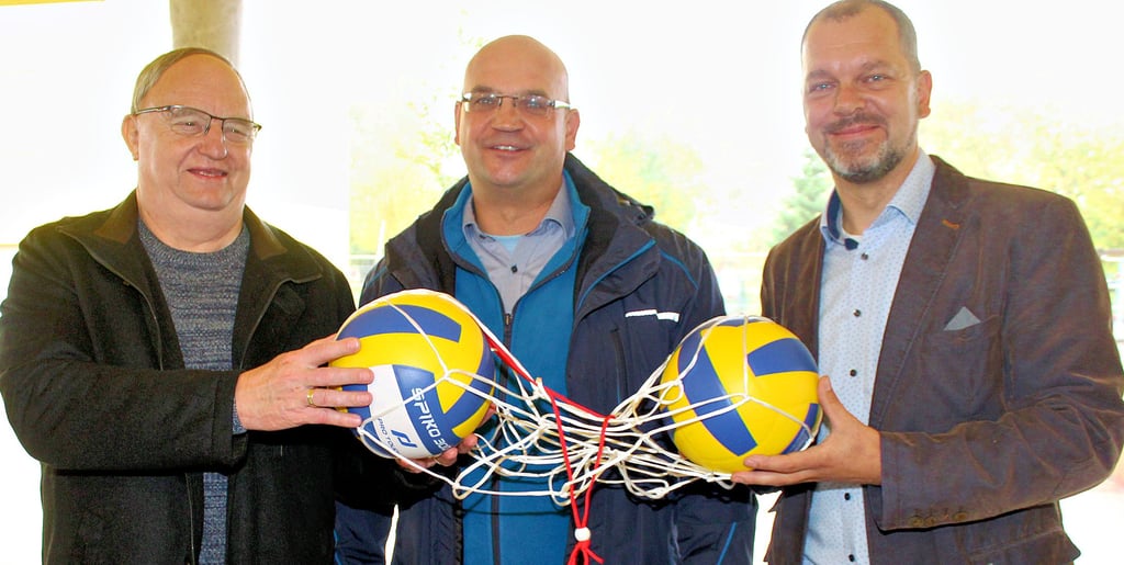 Bauamtsleiter Rüdiger Schmidt (Mitte) überreicht statt eines symbolischenSchlüssels für die Freigabe der neuen Einfeld-Sporthalle zwei Volleybälle: Einen an den Sportvereinsvorsitzenden Siegfried Kienast (l.) und einen an Schulleiter Maik Preikschas.