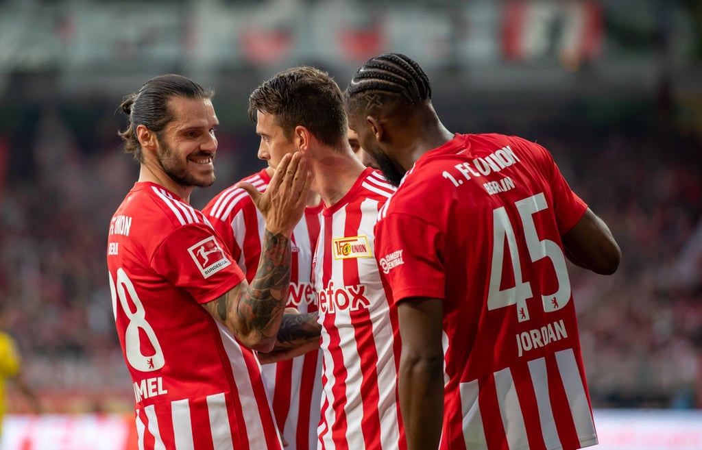 Union Berlins Christopher Trimmel (l) und Jordan Siebatcheu (r) gratulieren Janik Haberer zum 2:0.