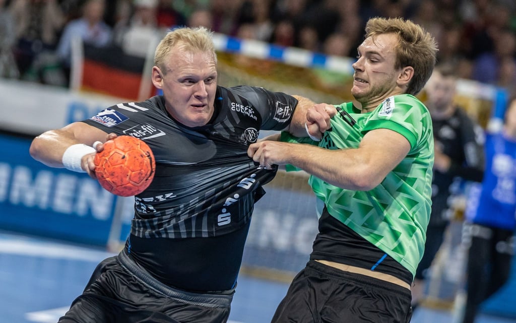 Patrick Wiencek von THW Kiel kämpft gegen Berlins Mathias Gidsel (r) um den Ball.