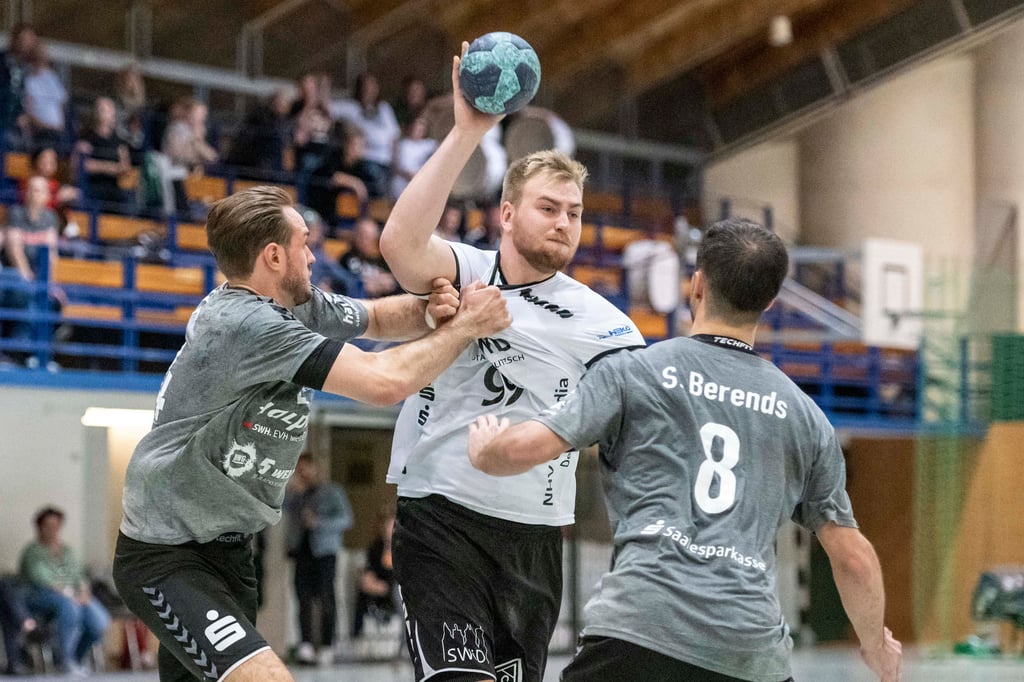 Halles Tom Kryszon (l.) und Sascha Berends (r.) verteidigen Delitzschs Maximilian Amtsberg beim Torwurf.
