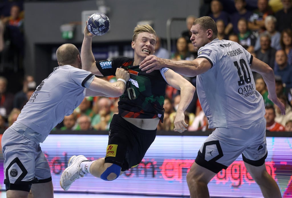 Henrik Toft Hansen (l) und Dainis Kristopans (l) von Paris Saint-Germain verteidigen am Wurfkreis gegen den Magdeburger Gisli Kristjansson.