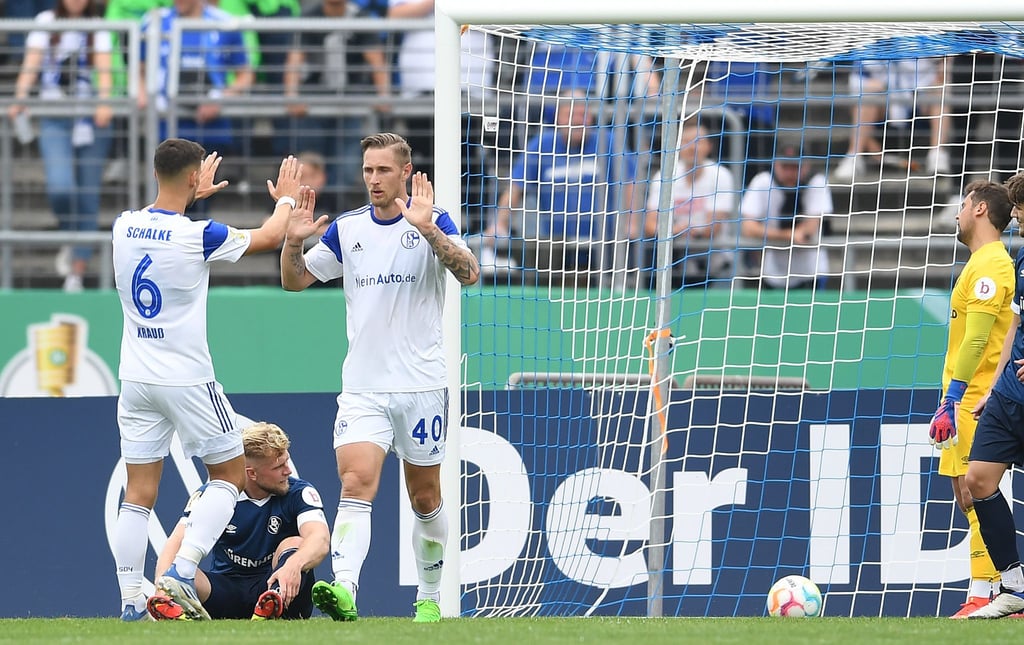 Schalkes Sebastian Polter (2.v.r.) und Tom Krauß (l) klatschen sich nach einem Tor ab.