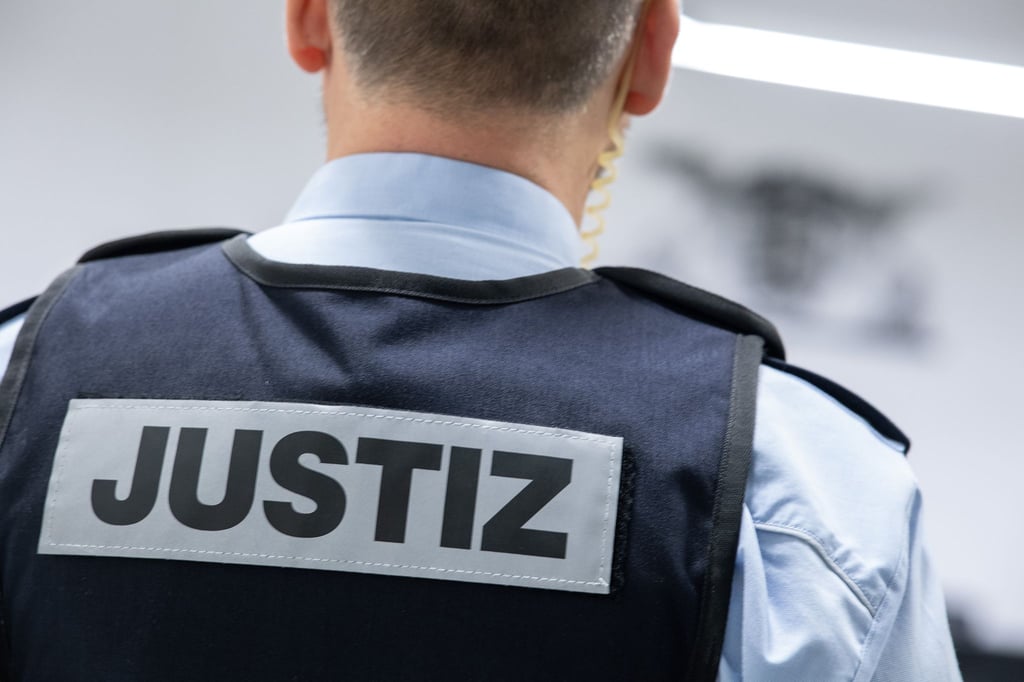 Ein Justizbeamter steht in einem Gerichtssaal.