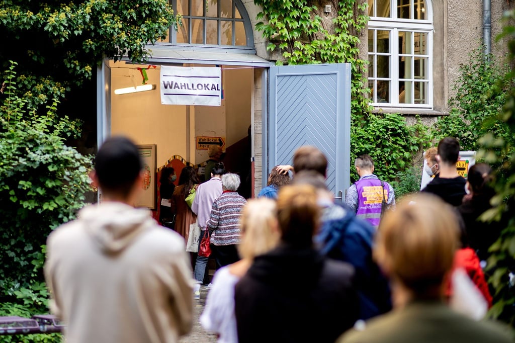 Zahlreiche Wählerinnen und Wähler warten im Berliner Stadtteil Prenzlauer Berg in einer langen Schlange vor einem Wahllokal, das in einer Grundschule untergebracht ist.