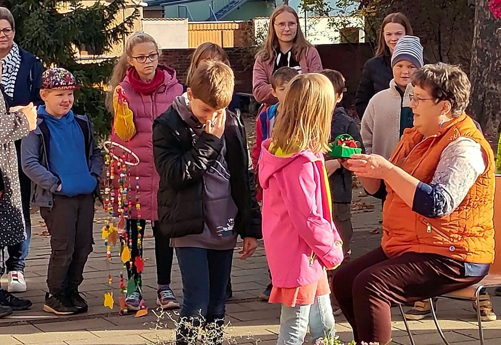 Wiebke Köbel (rechts) wird von den Kindern der zweiten Klasse mit einem gebastelten Erdbeerkörbchen aus Papier verabschiedet.